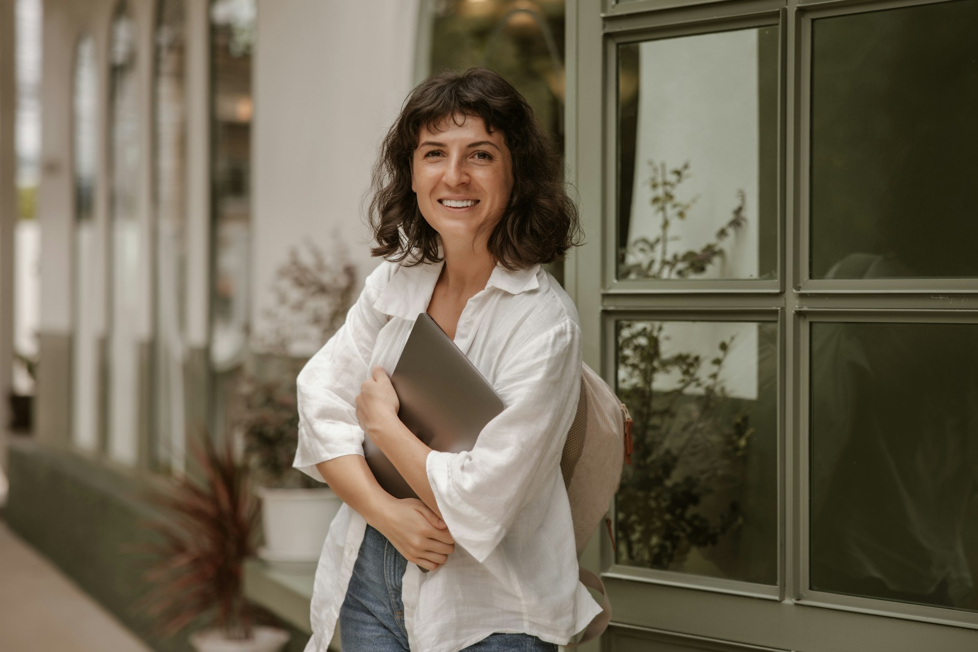 a woman standing outside of a building holding a folder